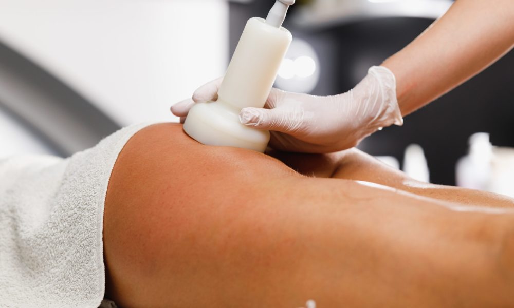 Shot of an unrecognizable woman getting an anti cellulite massage at the beauty salon. She have an ultrasound cavitacion treatment to fat reduction.